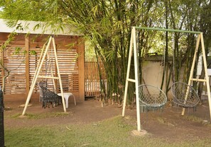 A bamboo grove with a swing set and a small white plastic chair. - Casual Eden Bayahibe by Casual Hoteles (Dominicus)