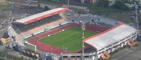An aerial view of a stadium with a running track, seating areas, and a large field.
