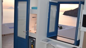 A room with a view of the sea, a door, a small table, and a chair. - A Alera Room and Breakfast (Malfa)