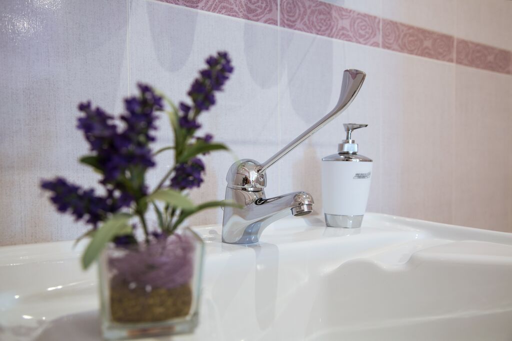 A bathroom sink with a modern faucet and a soap dispenser.