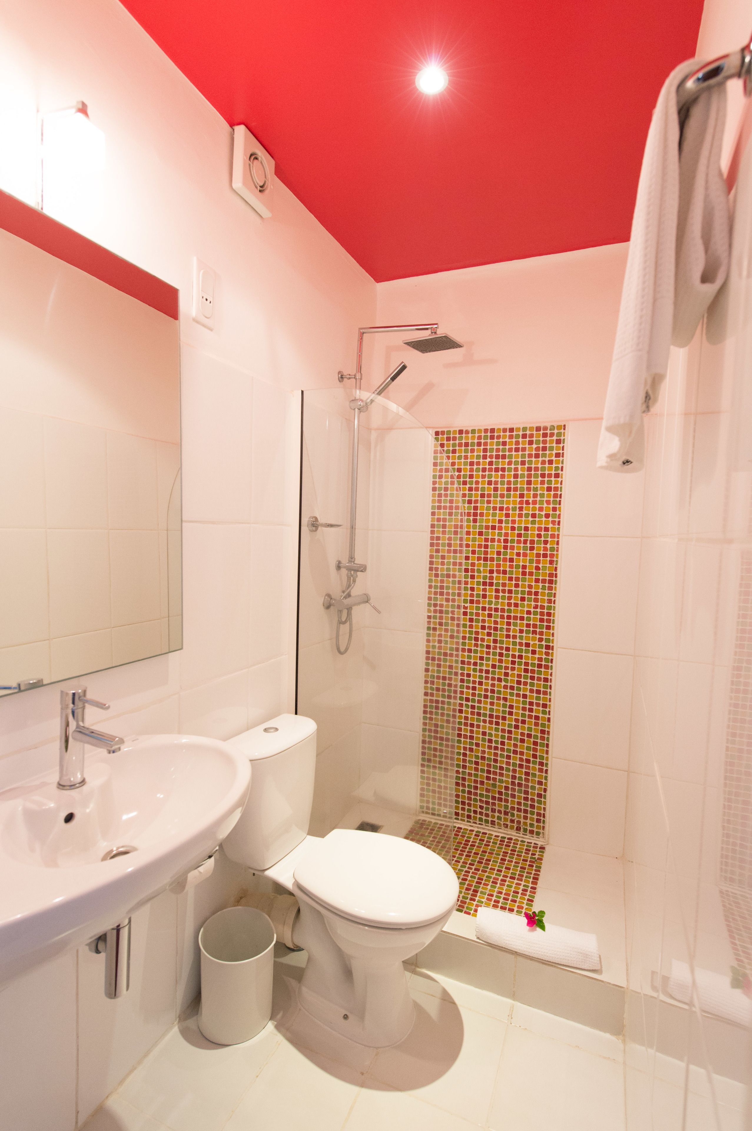 A bathroom with a white sink, toilet, and shower.