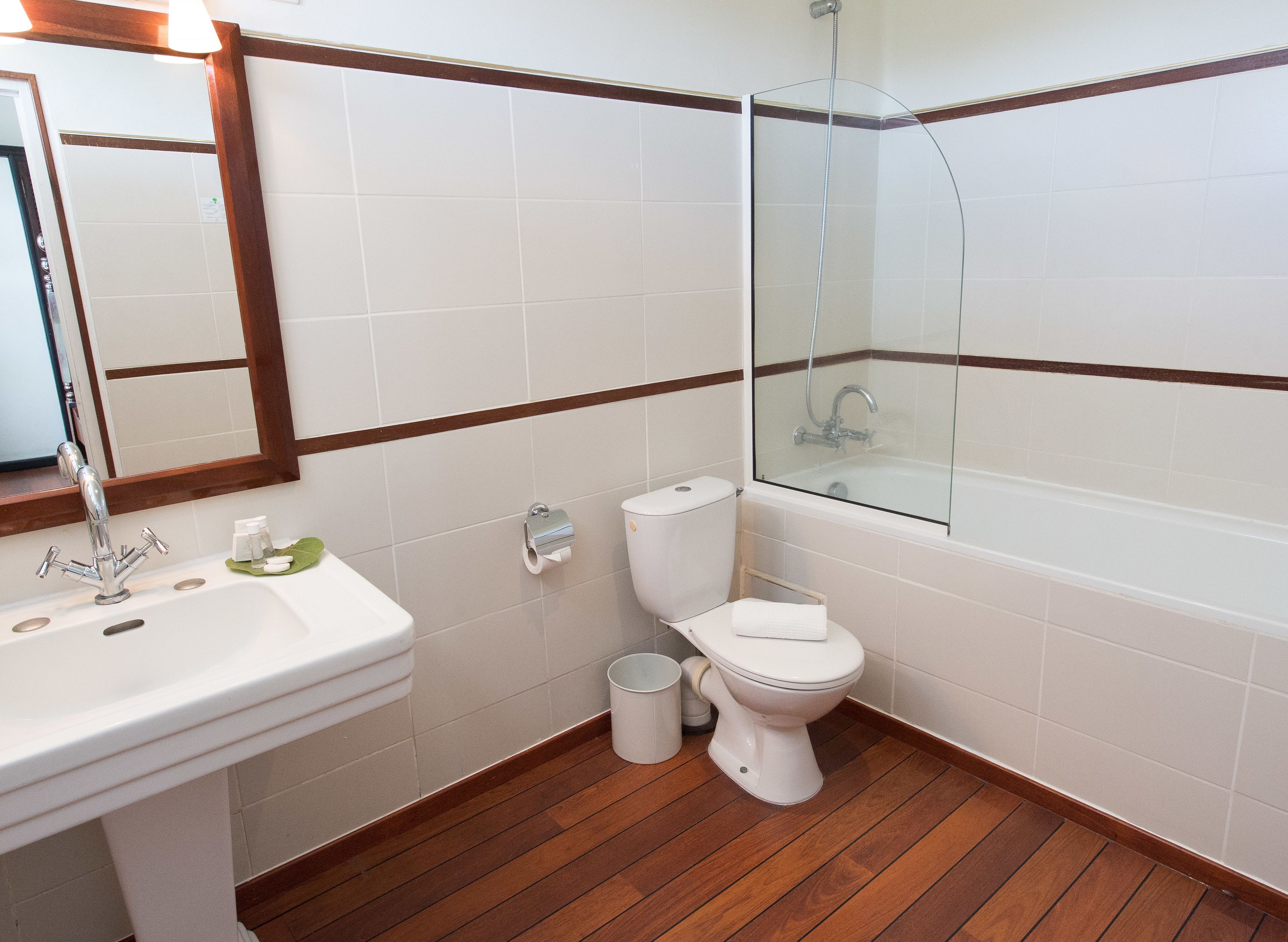 A bathroom with a sink, toilet, and glass-enclosed shower.
