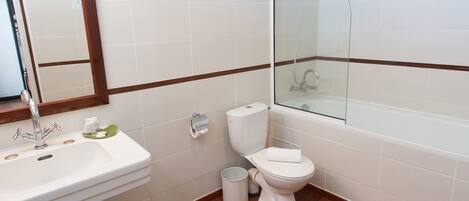 A bathroom with a sink, toilet, and glass-enclosed shower.
