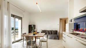 Een moderne keuken met een eethoek, een bank en uitzicht op het buiten.
