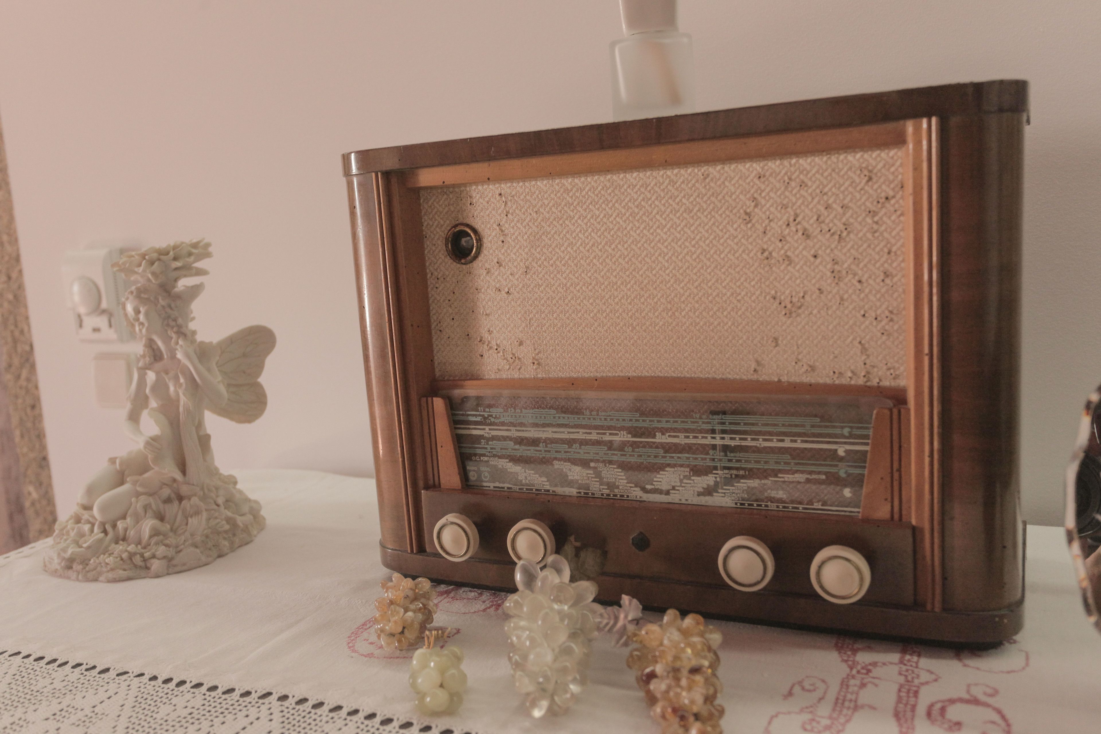 Une radio ancienne posée sur une table, entourée d’objets décoratifs.