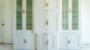 Un mueble blanco con puertas de cristal y tiradores.