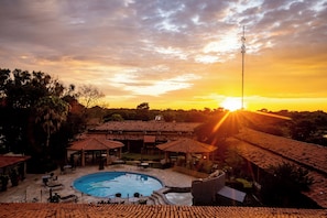 A resort with a swimming pool, outdoor seating, and a sunset view. - Pantanal Mato Grosso Hotel (Pocone)