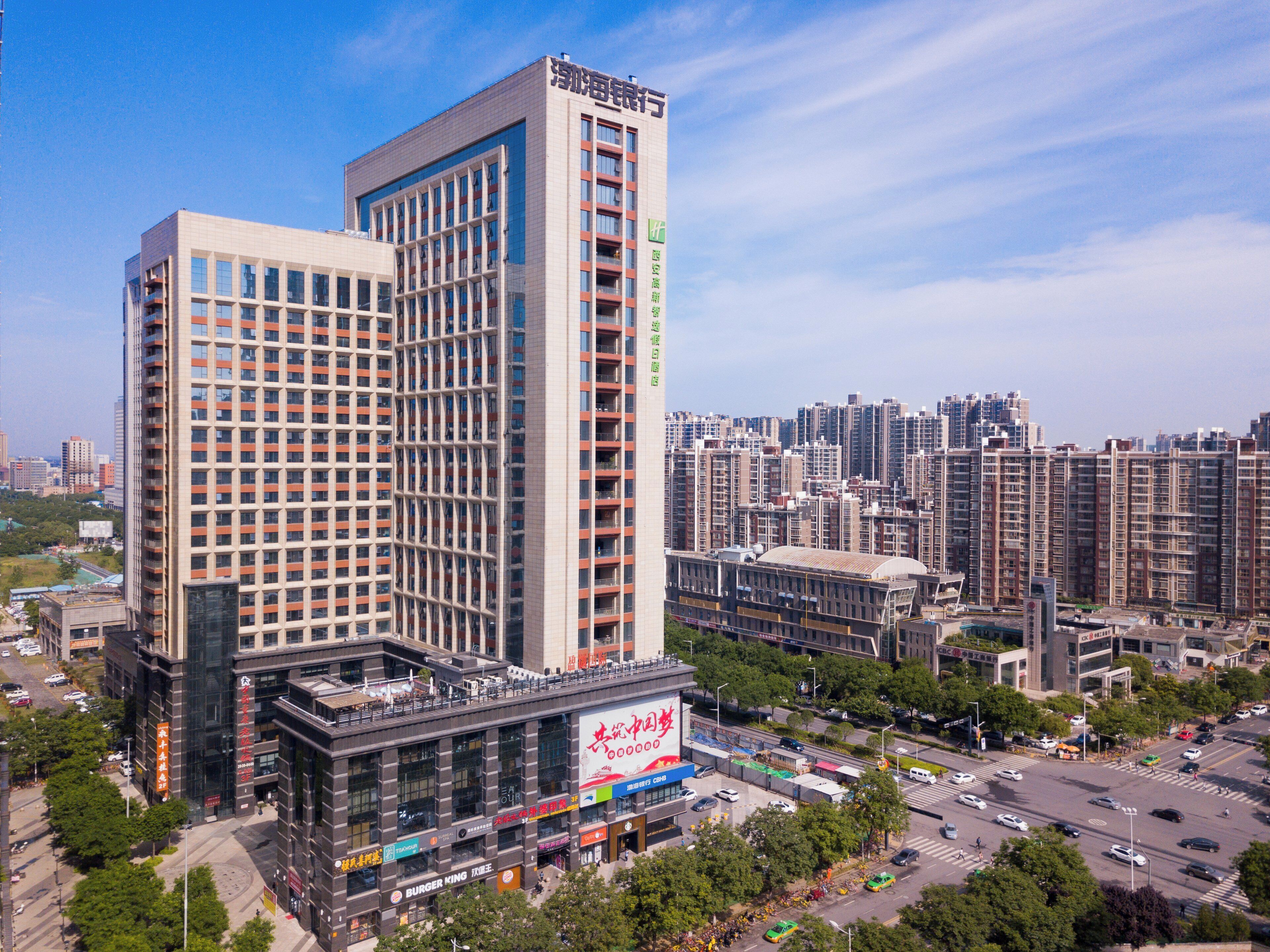 Un edificio de gran altura con varios pisos, rodeado de un paisaje urbano.