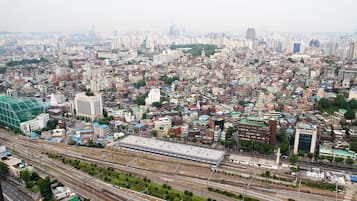 A cityscape with dense urban buildings, a prominent train station, and multiple railway tracks.