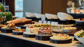 Un bufé con diversos platos y postres.