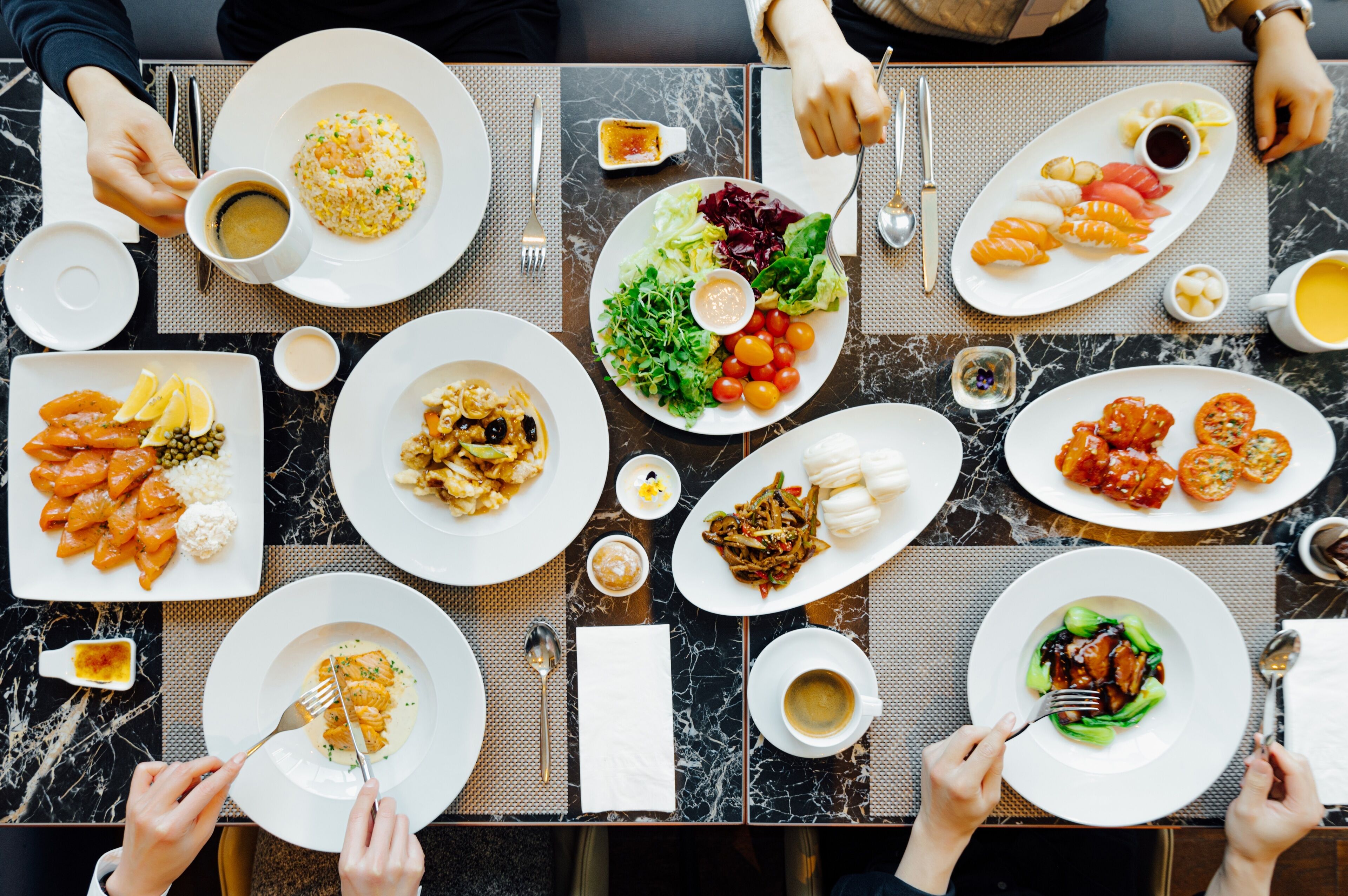 A dining table with various dishes, utensils, and condiments.