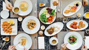Una mesa de comedor con diferentes platos, cubiertos y condimentos.