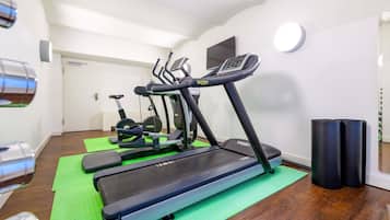 A home gym with treadmills, a stationary bike, and a weight bench.