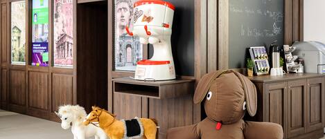 A room with a wooden cabinet, a large coffee machine, and a stuffed animal.