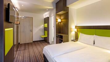 Habitació d'hotel amb un llit, escriptori, cadira i bany.