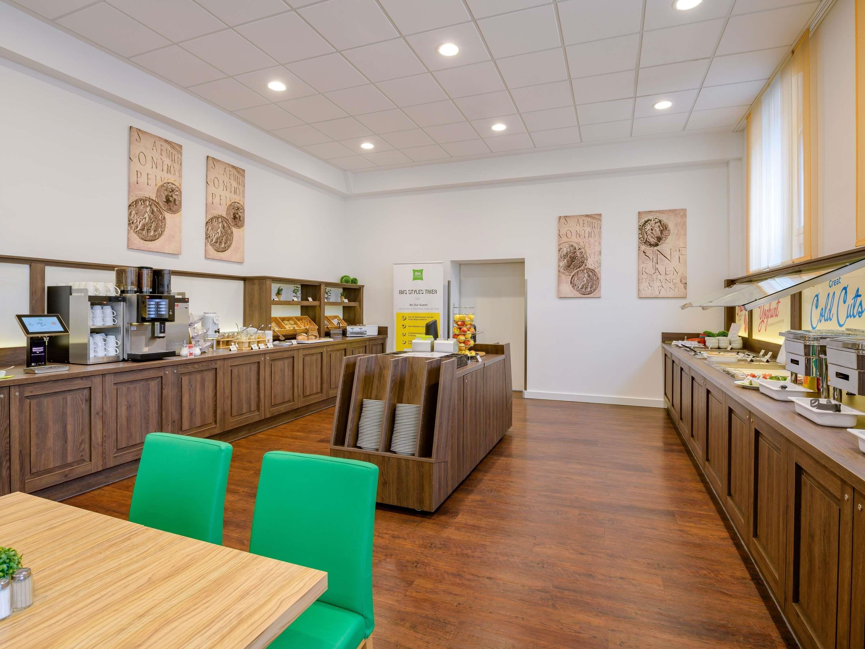 Een modern café met houten meubels, een koffieapparaat en een yoghurtdisplay.