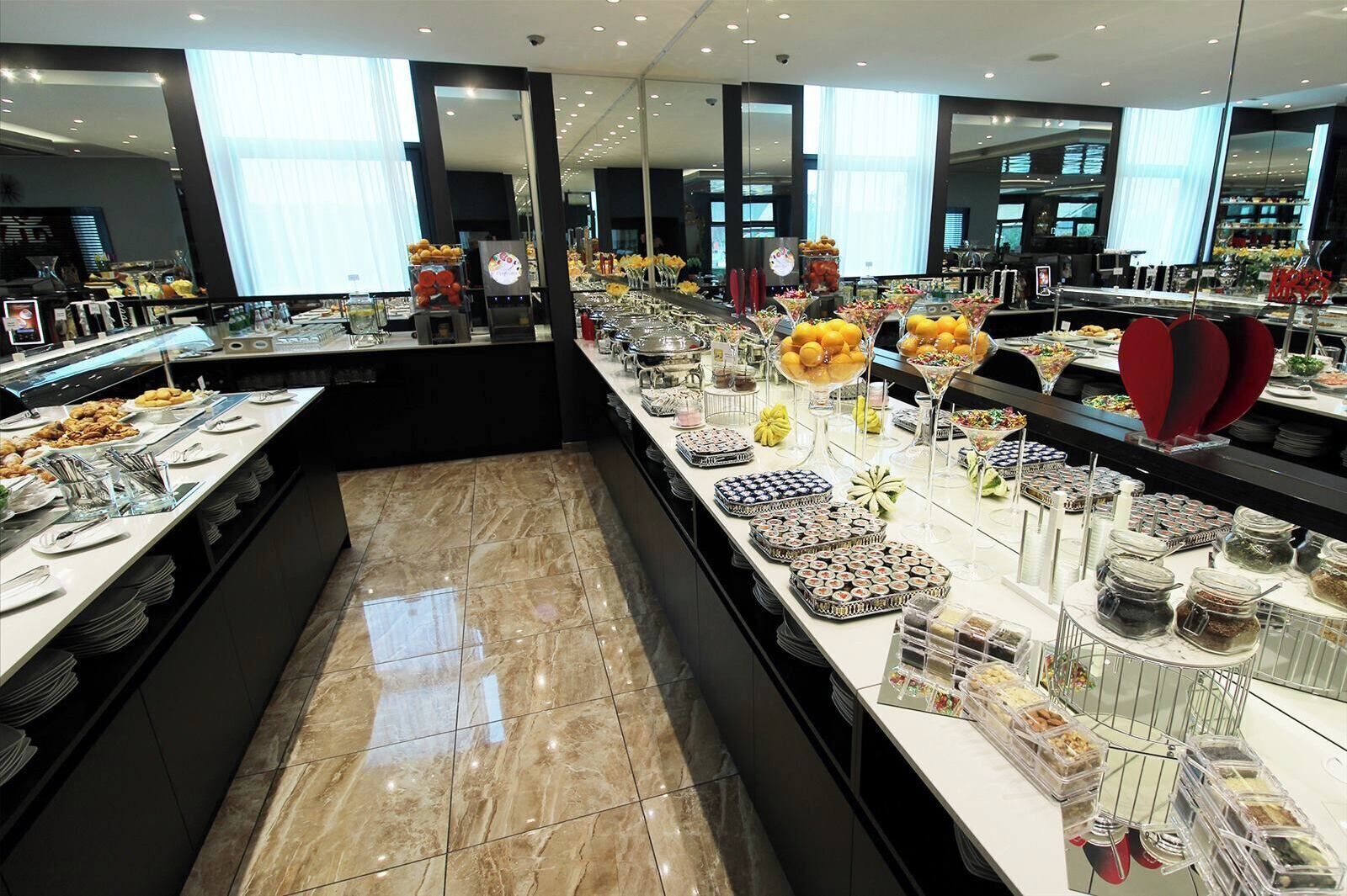 A buffet area with various food items and condiments.