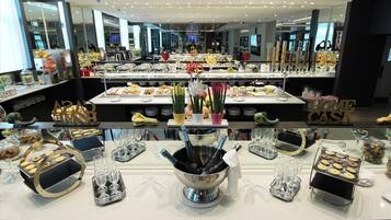 A buffet area with various food items, a champagne bucket, and a 'HOME CAST' sign.