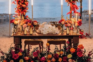 A beachside table set with flowers and candles, overlooking the sea. - Courtyard by Marriott Faro Blanco Resort, Marathon Florida Keys (Marathon)