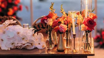 Une table ornée de différents vases contenant des fleurs et des bougies, probablement préparée pour un événement ou une cérémonie spéciale.