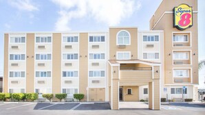 Un hôtel à plusieurs étages, doté d’une façade beige, d’une enseigne « Super 8 » bien visible et d’un parking situé à l’avant.