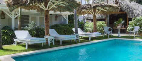 Een buitenzwembad en ligstoelen