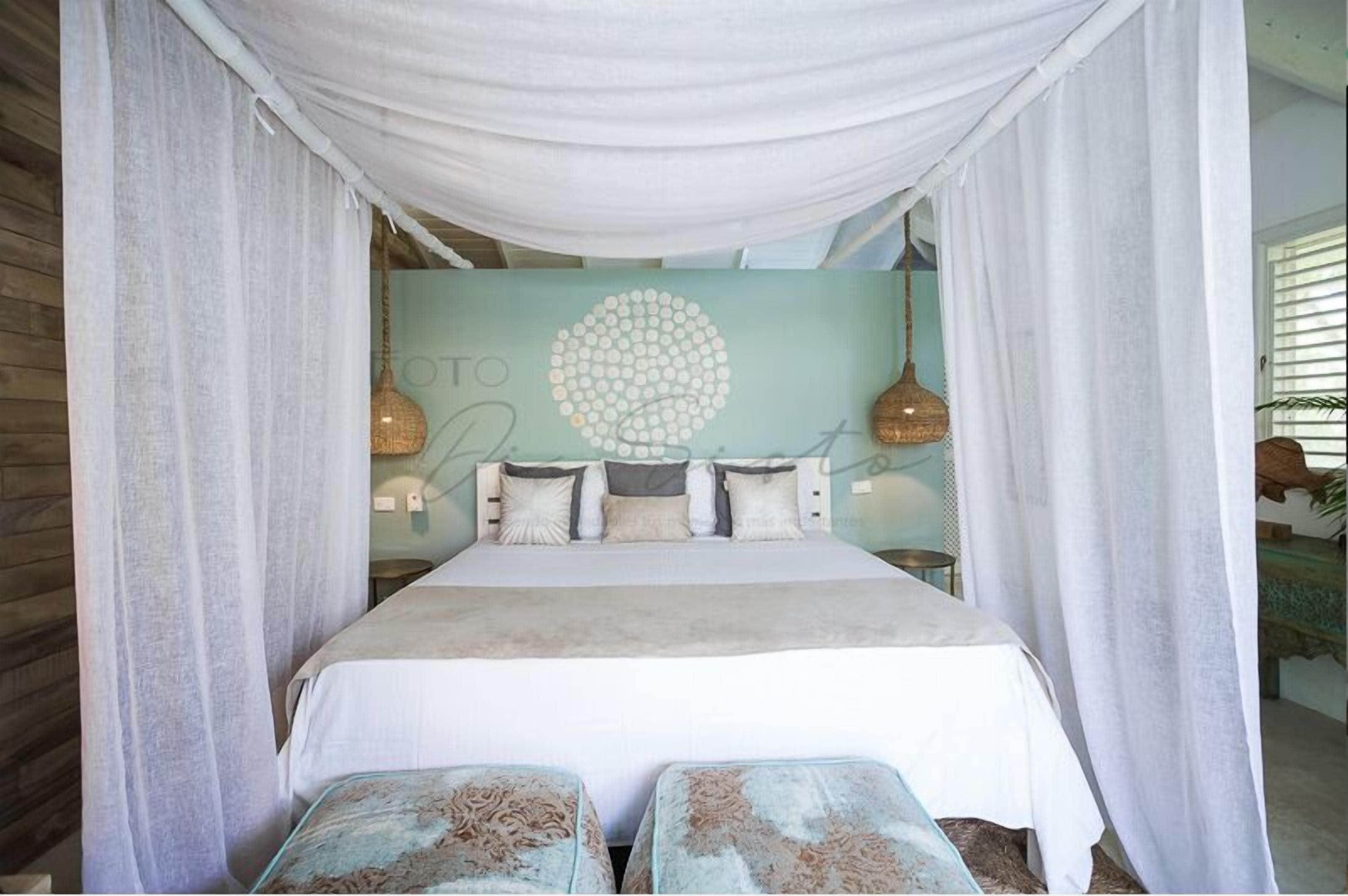 A bed with a canopy, a circular wall decoration, and a bed with a light blue wall behind it.