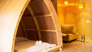 A cozy wooden room with a bed, a chair, and a heater. - Laranjalimao Guest House (Ponte de Lima)