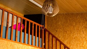 A wooden interior with a staircase, a hanging light fixture, and a potted plant. - Laranjalimao Guest House (Ponte de Lima)
