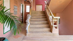 A staircase with a decorative handrail and a potted plant on the left. - Casa Brazil Homestay & Gallery (Karon)