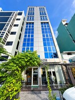 Un edificio moderno con una entrada destacada, ventanas amplias y un cartel que dice 'RIVETHI'.