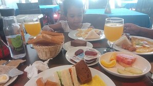 A dining table with various breakfast items including toast, eggs, and sandwiches.