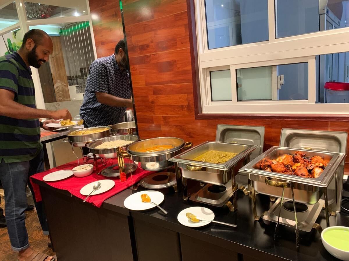 A buffet setup with various food items and serving utensils.