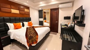 A modern hotel room with a large bed, a desk, and a television.