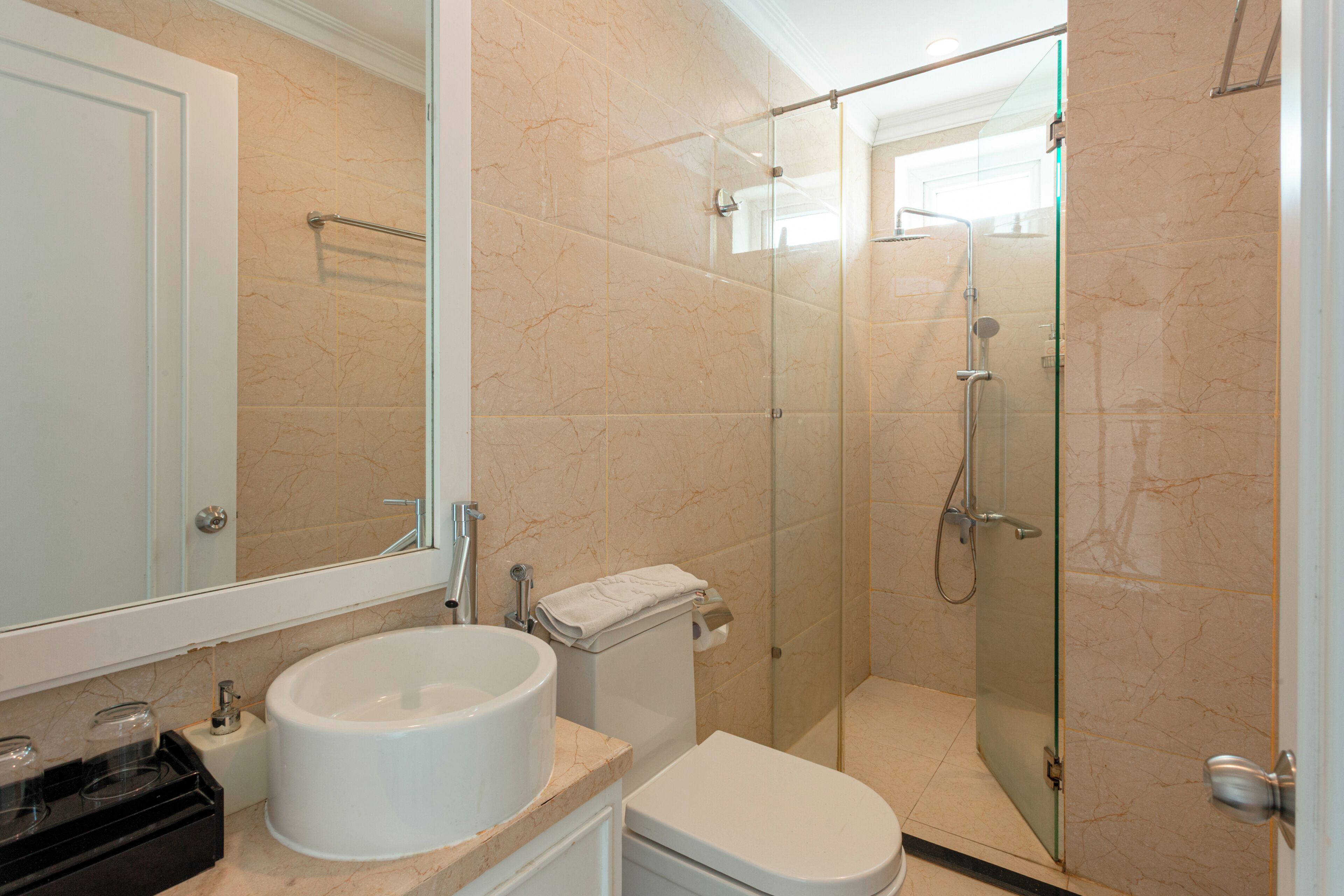 A bathroom with a sink, toilet, and glass-enclosed shower.