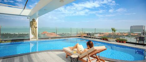 Alberca al aire libre, sombrillas en la alberca y camastros