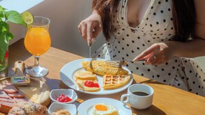 A breakfast table with waffles, toast, fruit, and a glass of orange juice. - Sea Phoenix Hotel Da Nang (Da Nang)