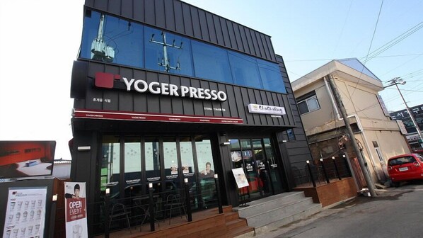 Un bâtiment dont la devanture porte l’inscription « YOGER PRESSO ».