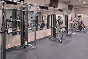 A gym with various exercise machines, mirrors, and a carpeted floor. - Holiday Inn Express & Suites Houston E - Pasadena by IHG (Pasadena)