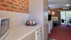 Une petite cuisine équipée d’une machine à café, de tasses et d’un plateau de dosettes de café.