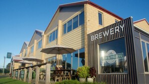 Une brasserie à l’architecture moderne, dotée d’une terrasse et offrant une vue sur un ciel dégagé.