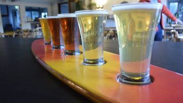 A row of shot glasses on a wooden tray.