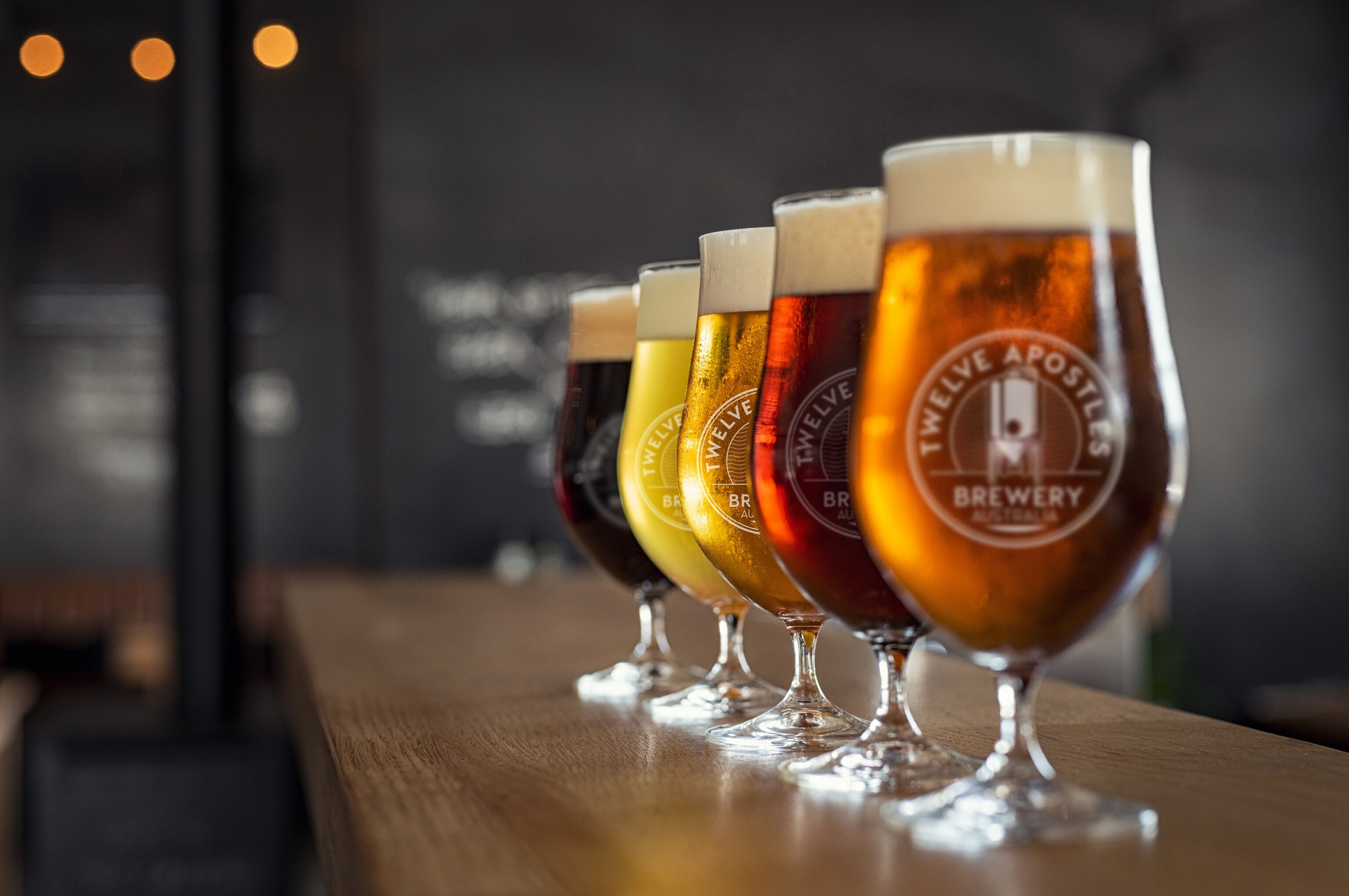 Diverses copes de cervesa damunt un taulell de bar de fusta.
