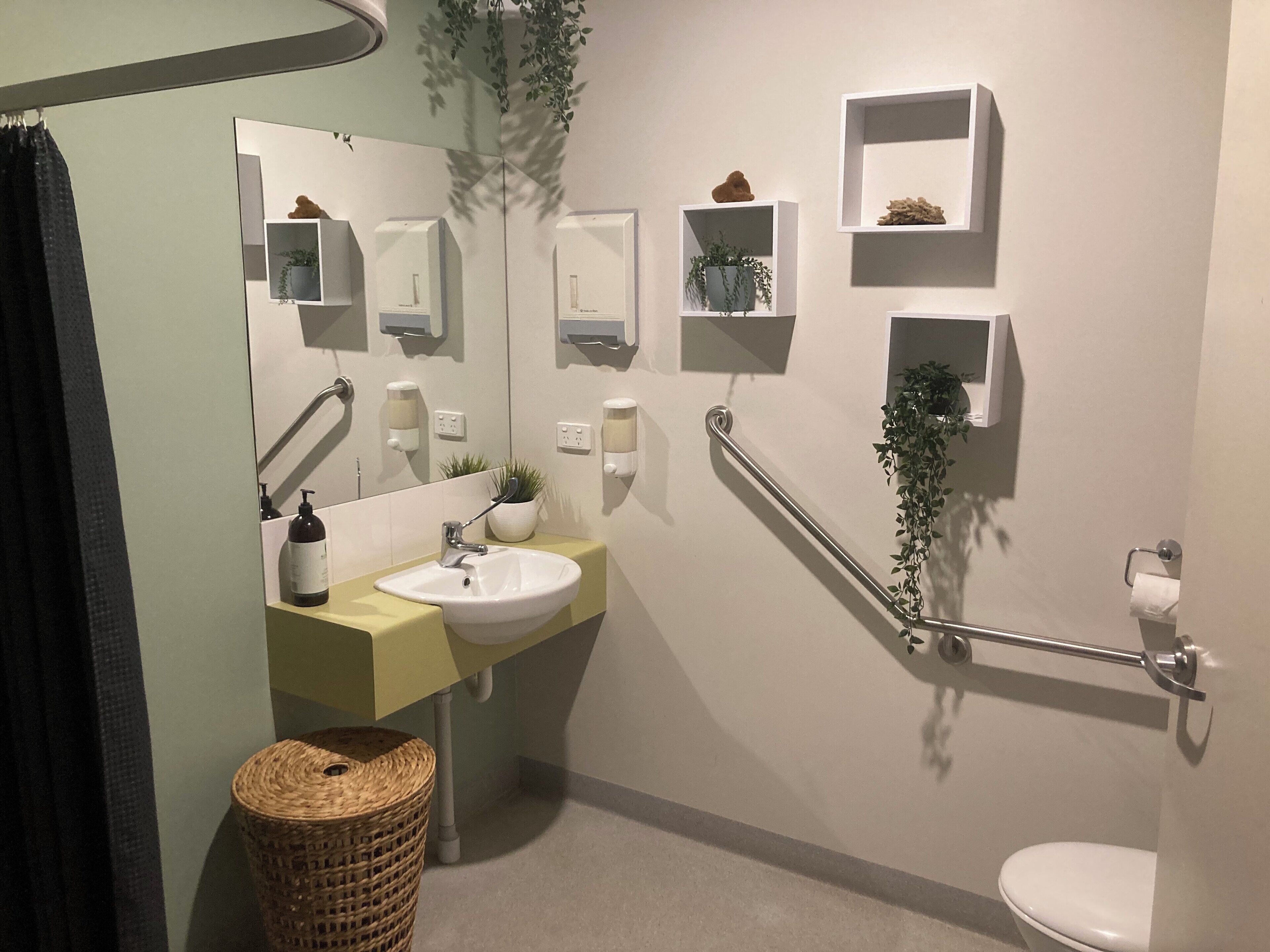Un baño moderno con lavamanos, espejo, toallero y retrete.