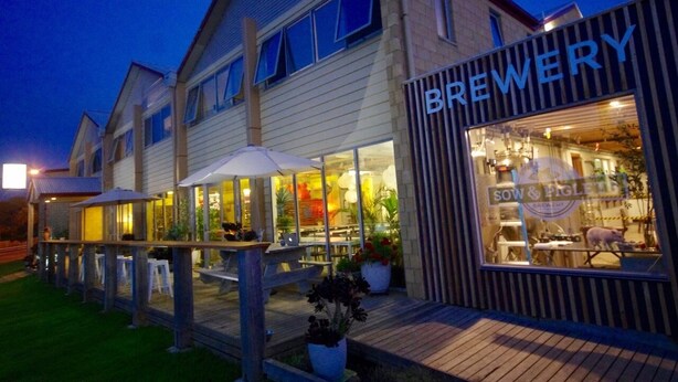 Une brasserie dotée d’une terrasse et dont la devanture est bien éclairée.