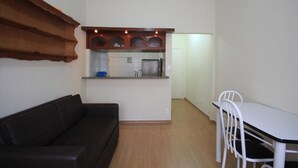Um espaço compacto com cozinha compacta, área de refeições e espaço de estar.