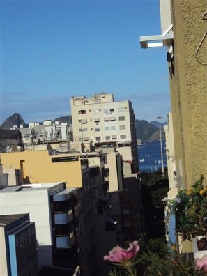 Vista de una zona residencial con edificios, una montaña y una masa de agua al fondo.