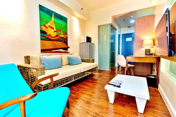 A modern living room with a sofa, a coffee table, and a painting of a sailboat. - The Ferra Premier by JG (Boracay Island)