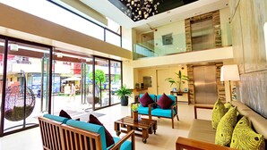 Een ruime lobby met een hoge plafond, grote ramen en een modern interieur.