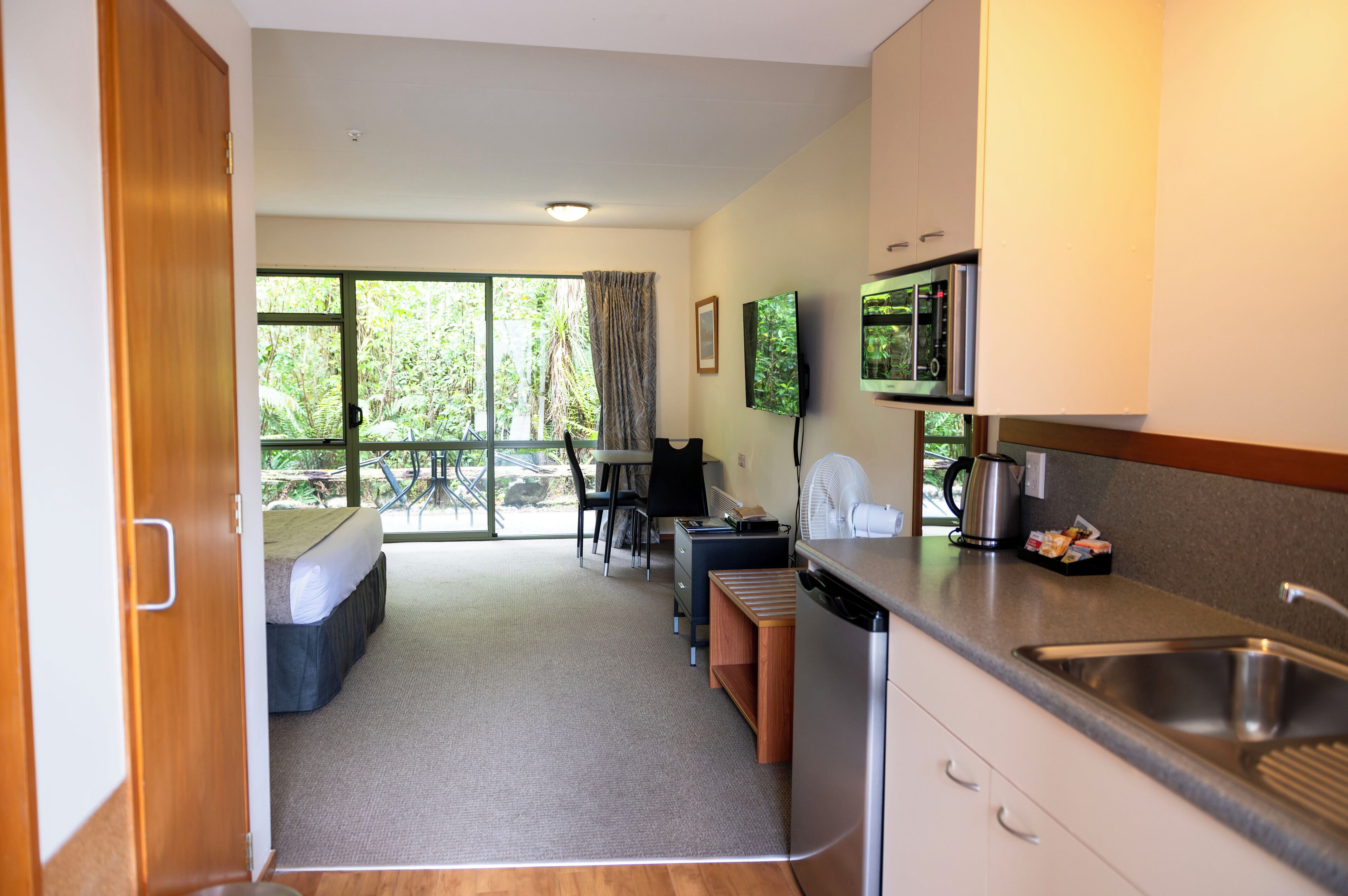 A compact kitchen with a sink, stove, and a dining area with a table and chairs.